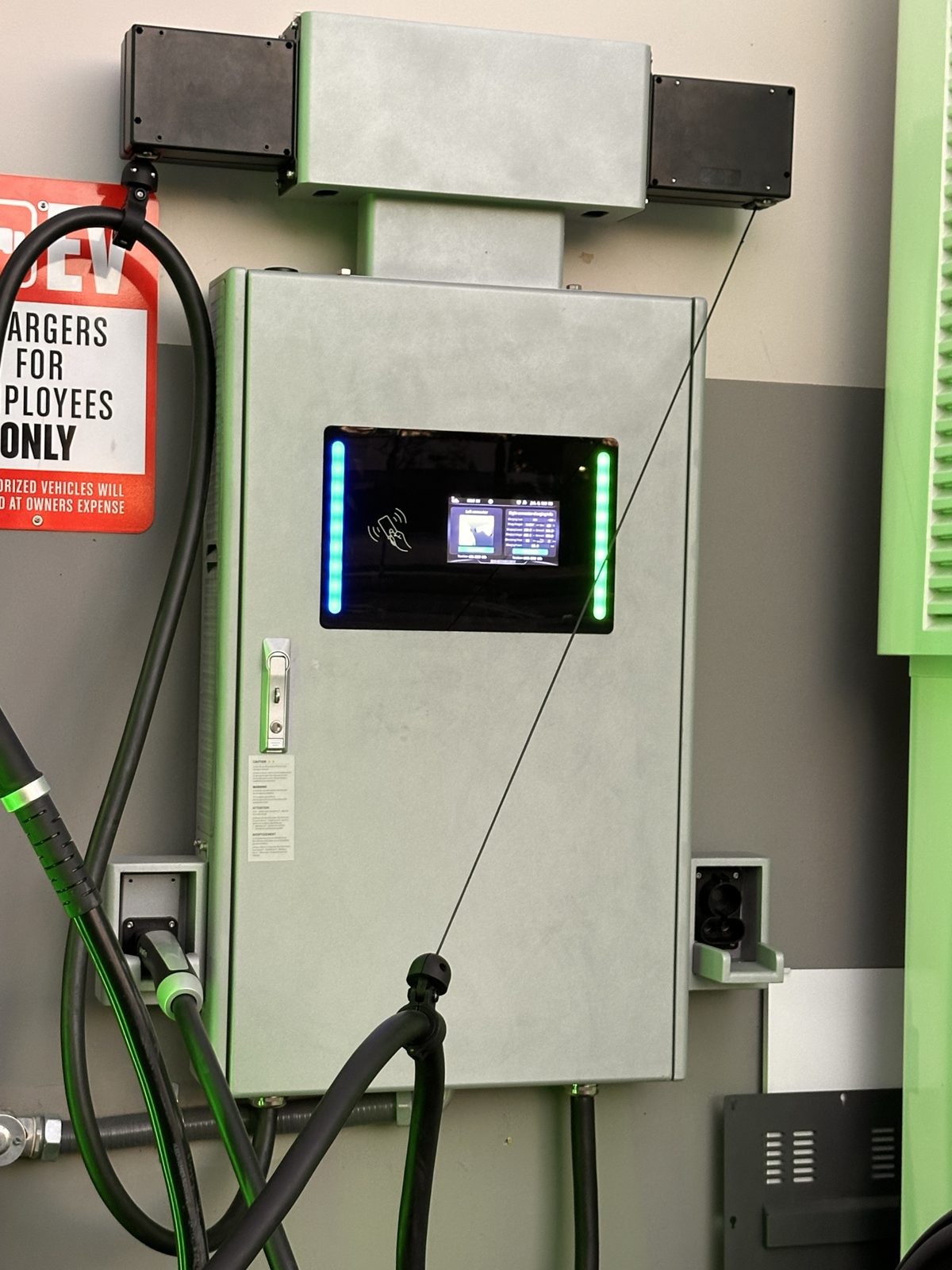 Wall-mounted DC fast charger at an employee fleet site